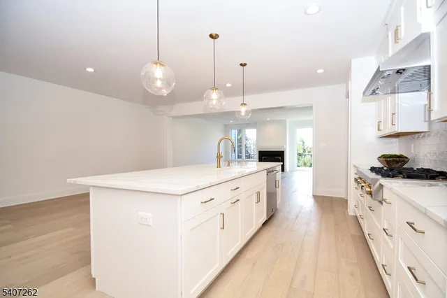 a large white kitchen with wooden floor