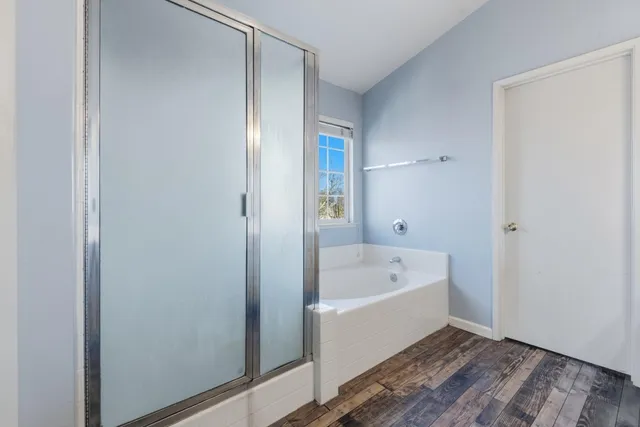 a bathroom with a tub shower and sink