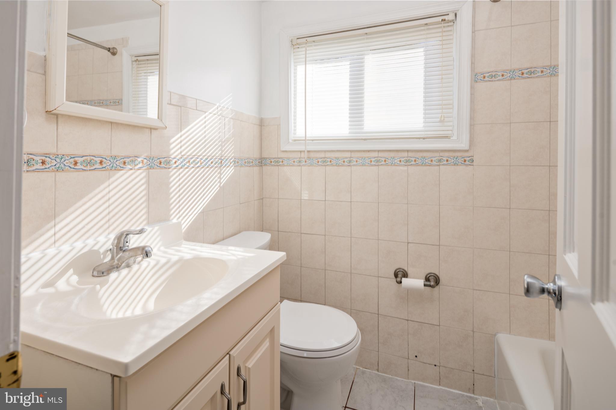 6319 Longfellow Street Riverdale, MD 20737 - Photo 15 of 40 a bathroom with a sink toilet and vanity