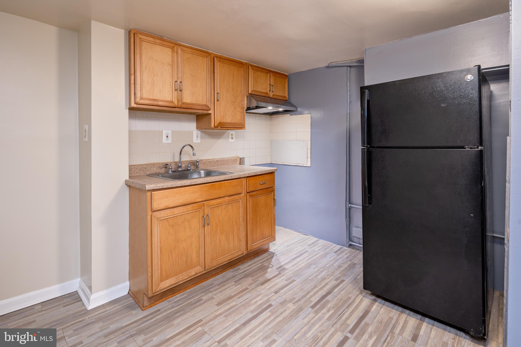 6319 Longfellow Street Riverdale, MD 20737 - Photo 27 of 40 a kitchen with a refrigerator sink and cabinets
