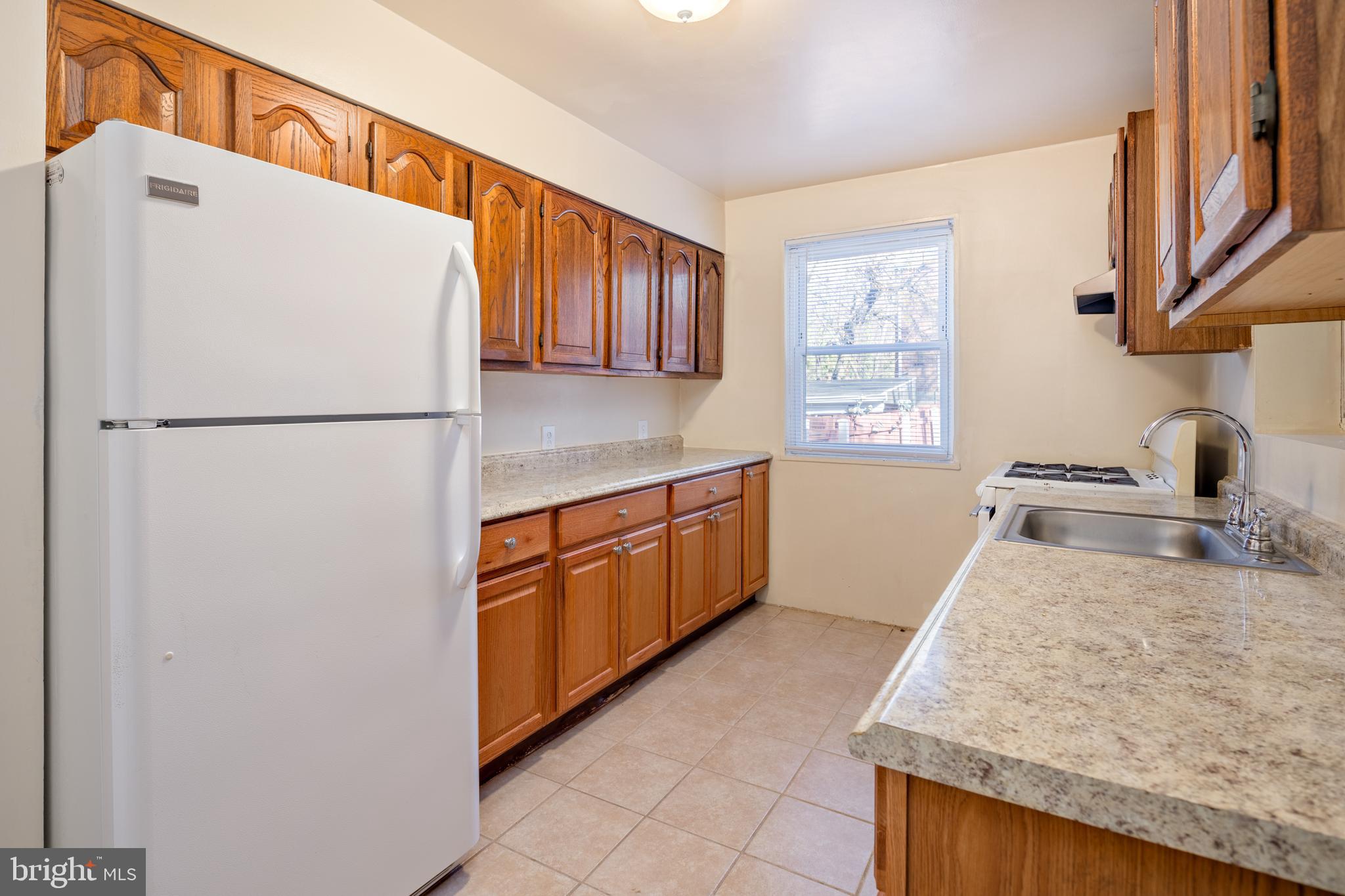 6319 Longfellow Street Riverdale, MD 20737 - Photo 6 of 40 a white refrigerator freezer sitting inside of a kitchen