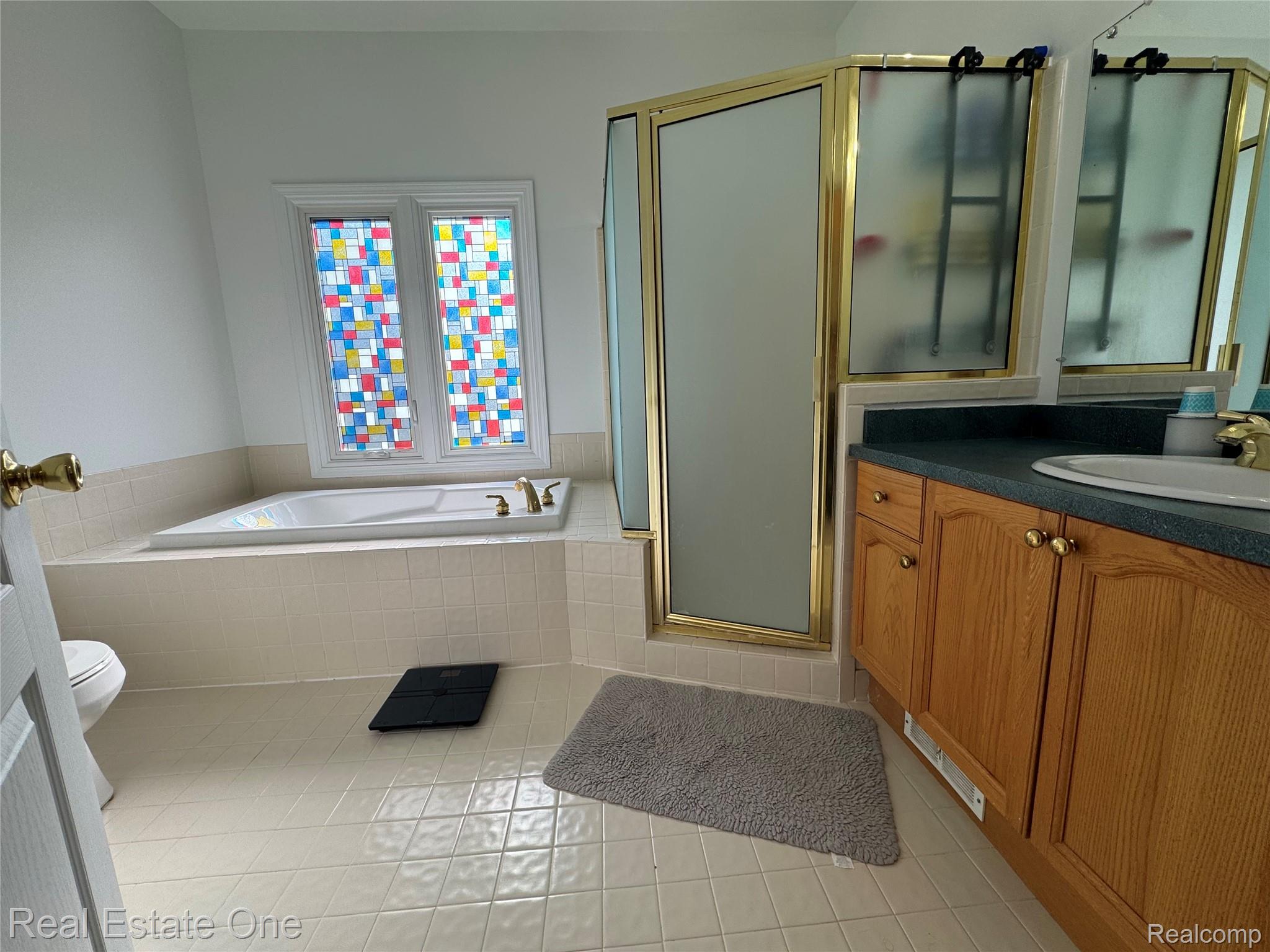 1668 South Shore Drive Rochester, MI 48307 - Photo 16 of 27 Full bathroom featuring a bath, a stall shower, light tile patterned flooring, and vanity