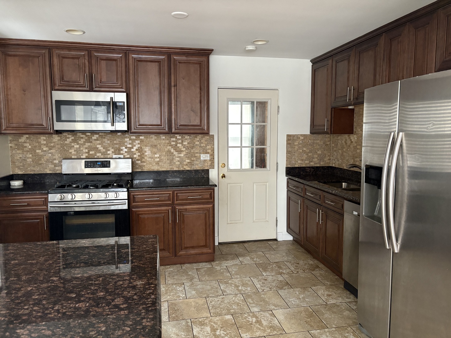 751 North Northwest Highway Park Ridge, IL 60068 - Photo 20 of 25 a kitchen with granite countertop a refrigerator and a stove top oven