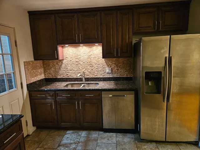 a kitchen with granite countertop cabinets and steel stainless steel appliances