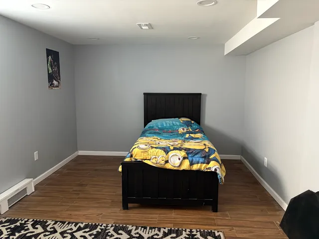 a bed sitting in a bedroom and night stand