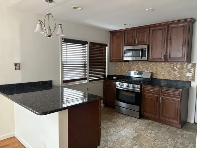 a kitchen with stainless steel appliances granite countertop a stove and a microwave