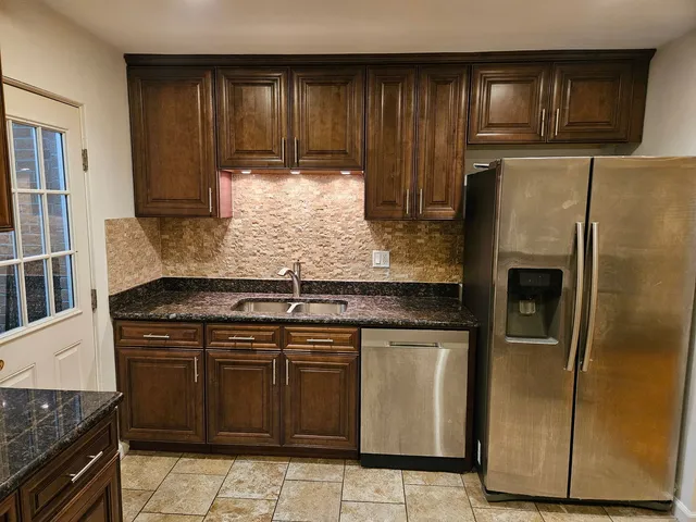 a kitchen with stainless steel appliances granite countertop a stove a refrigerator and a sink