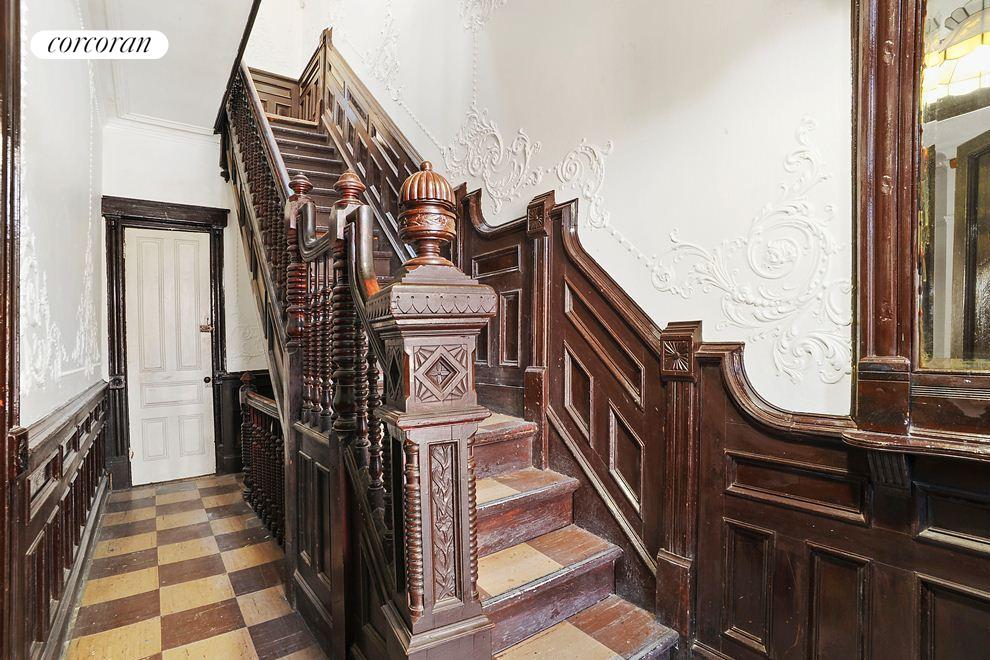 a view of a hallway with wooden floor and staircase