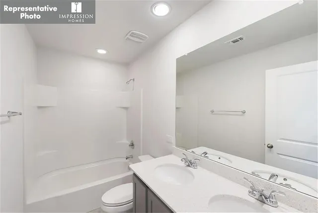 a bathroom with a bathtub shower sink vanity and toilet