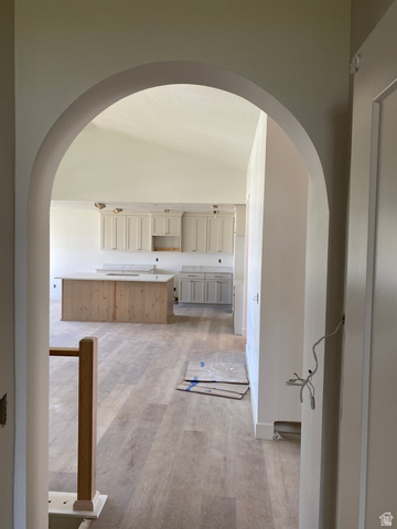 4676 West 75 North, Unit 401 West Point, UT 84015 - Photo 11 of 17 Arched doorway opening to an open-concept living space with wood-finish flooring
