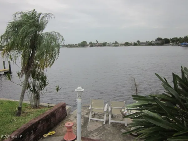 a view of a lake with lawn chairs