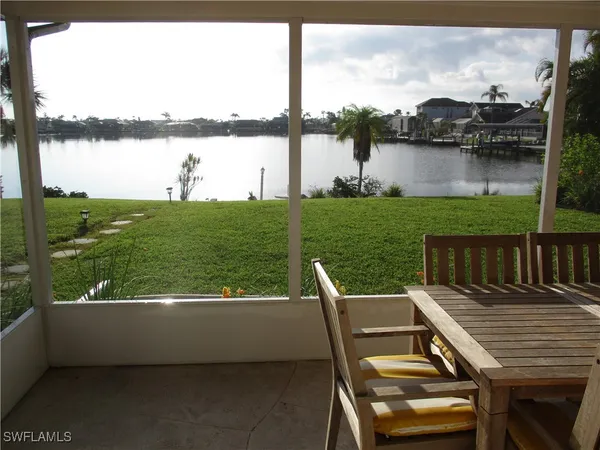 a view of a lake from a balcony with outdoor seating