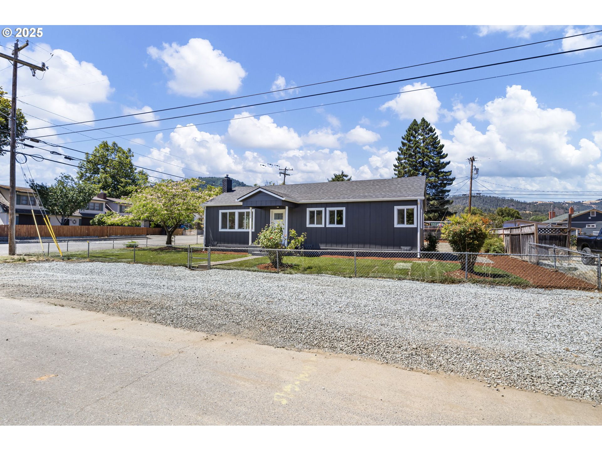 514 East 2nd Avenue Riddle, OR 97469 - Photo 2 of 16 a front view of a house with a yard and a garage
