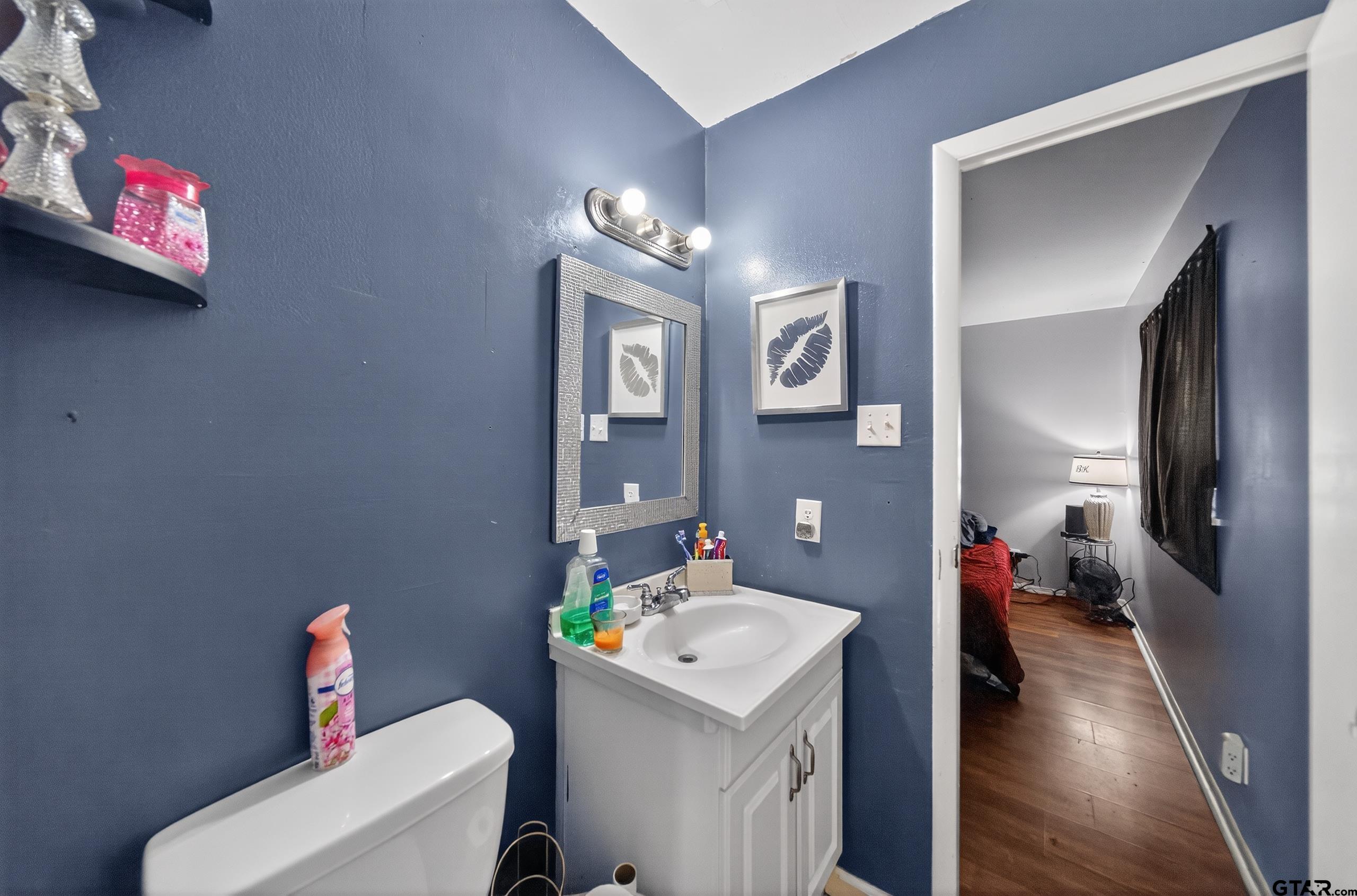 3165 Jackson Avenue Tyler, TX 75705 - Photo 12 of 24 a bathroom with a toilet sink and mirror