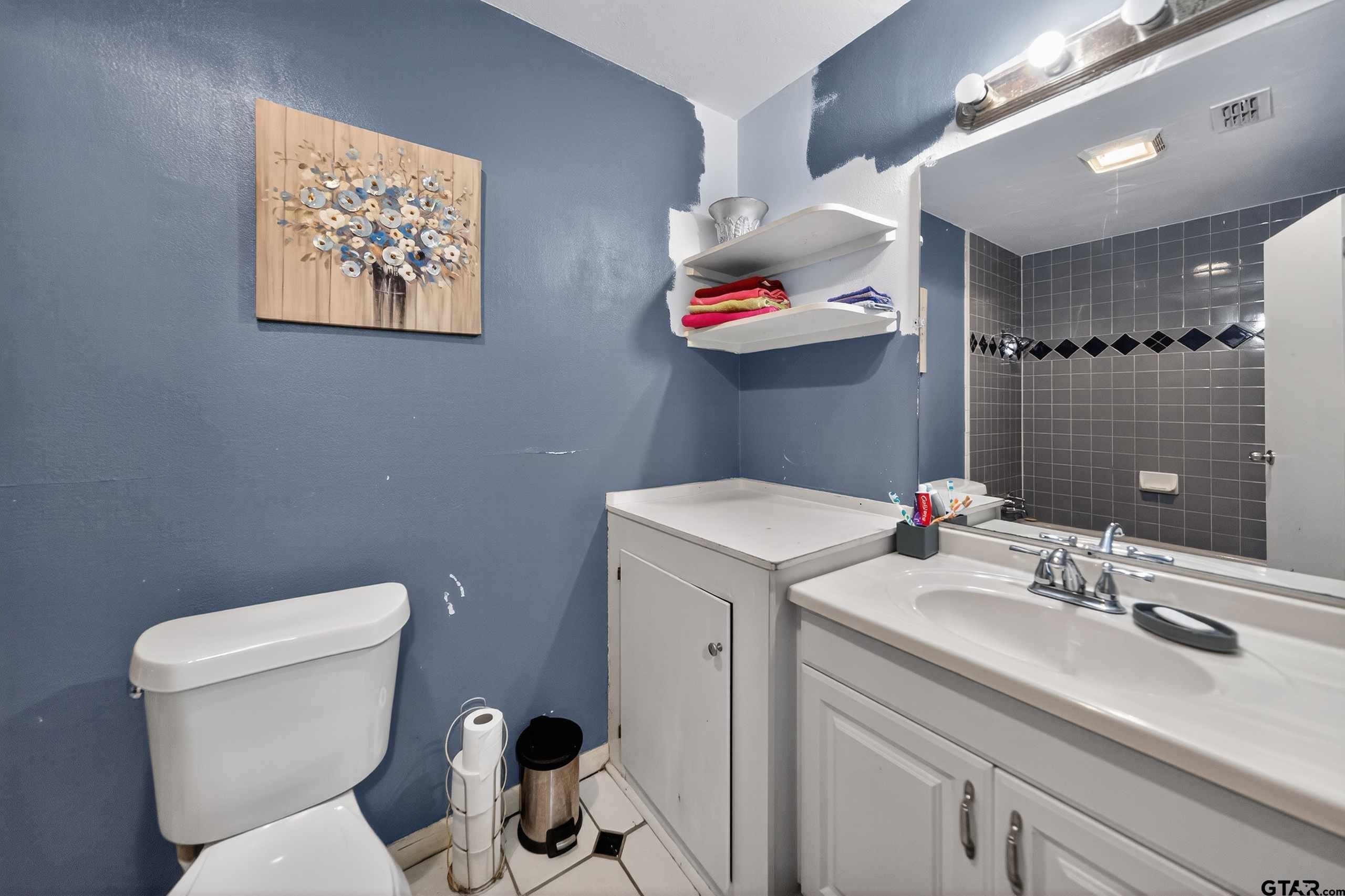 3165 Jackson Avenue Tyler, TX 75705 - Photo 17 of 24 a bathroom with a toilet sink and mirror