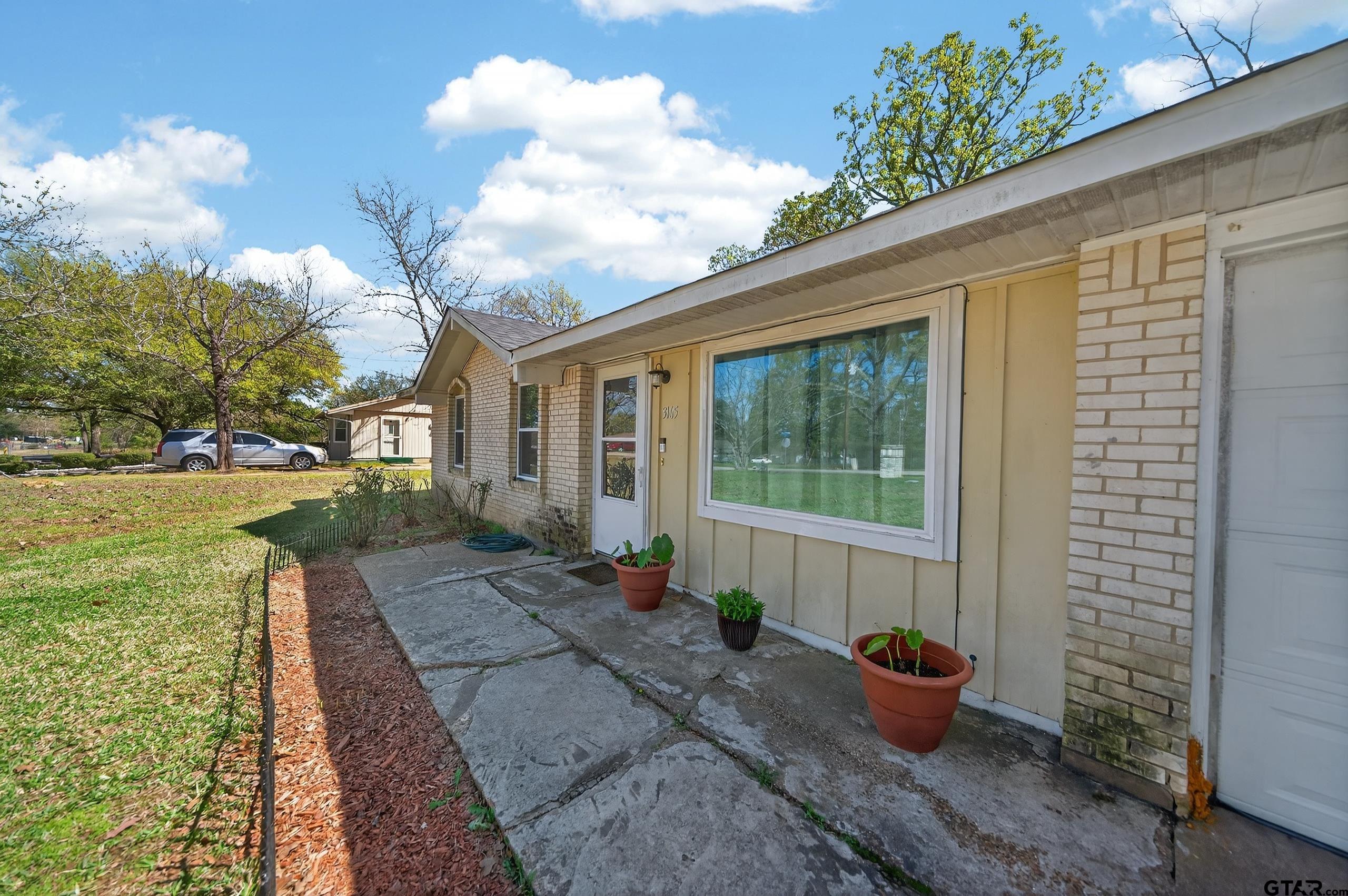 3165 Jackson Avenue Tyler, TX 75705 - Photo 3 of 24 a view of a backyard with sitting area and garden