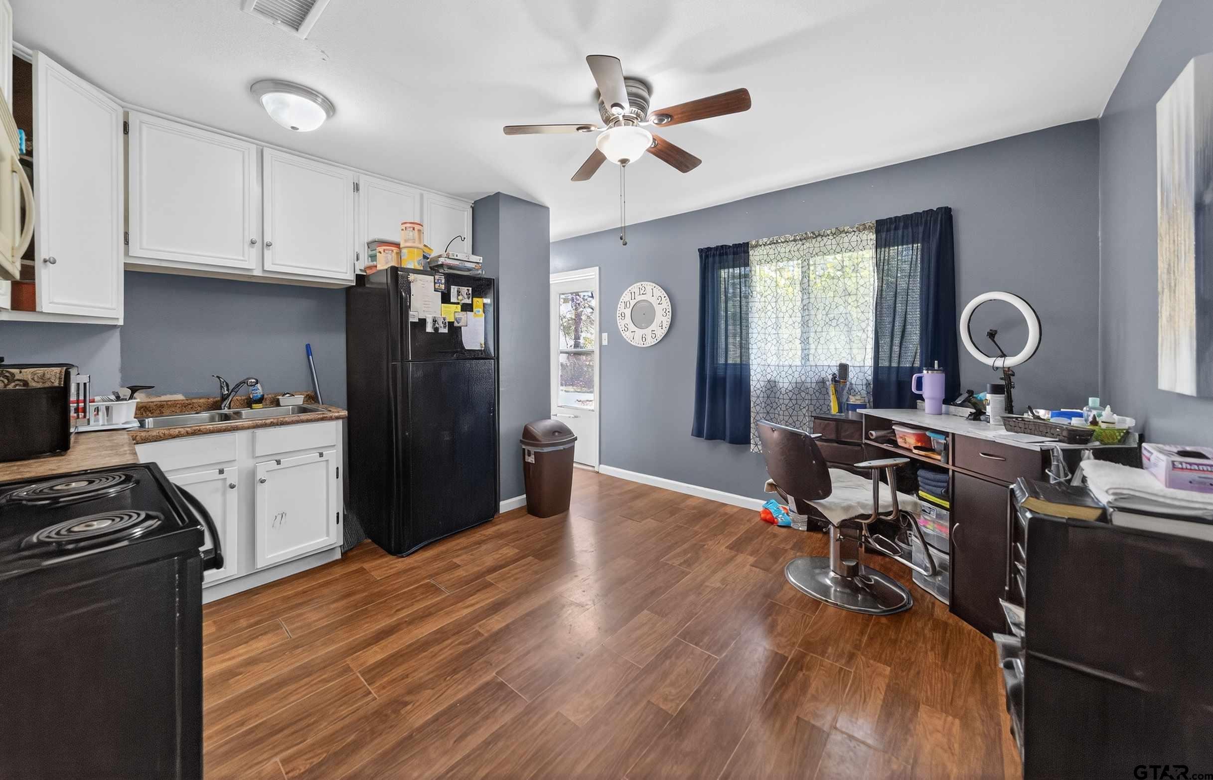 3165 Jackson Avenue Tyler, TX 75705 - Photo 6 of 24 a kitchen with a table chairs refrigerator and cabinets