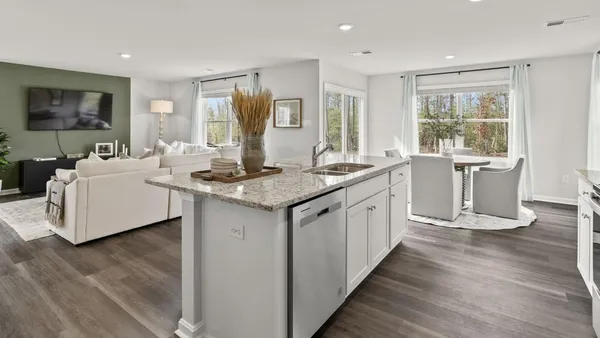 a kitchen that has a sink a stove and wooden floor