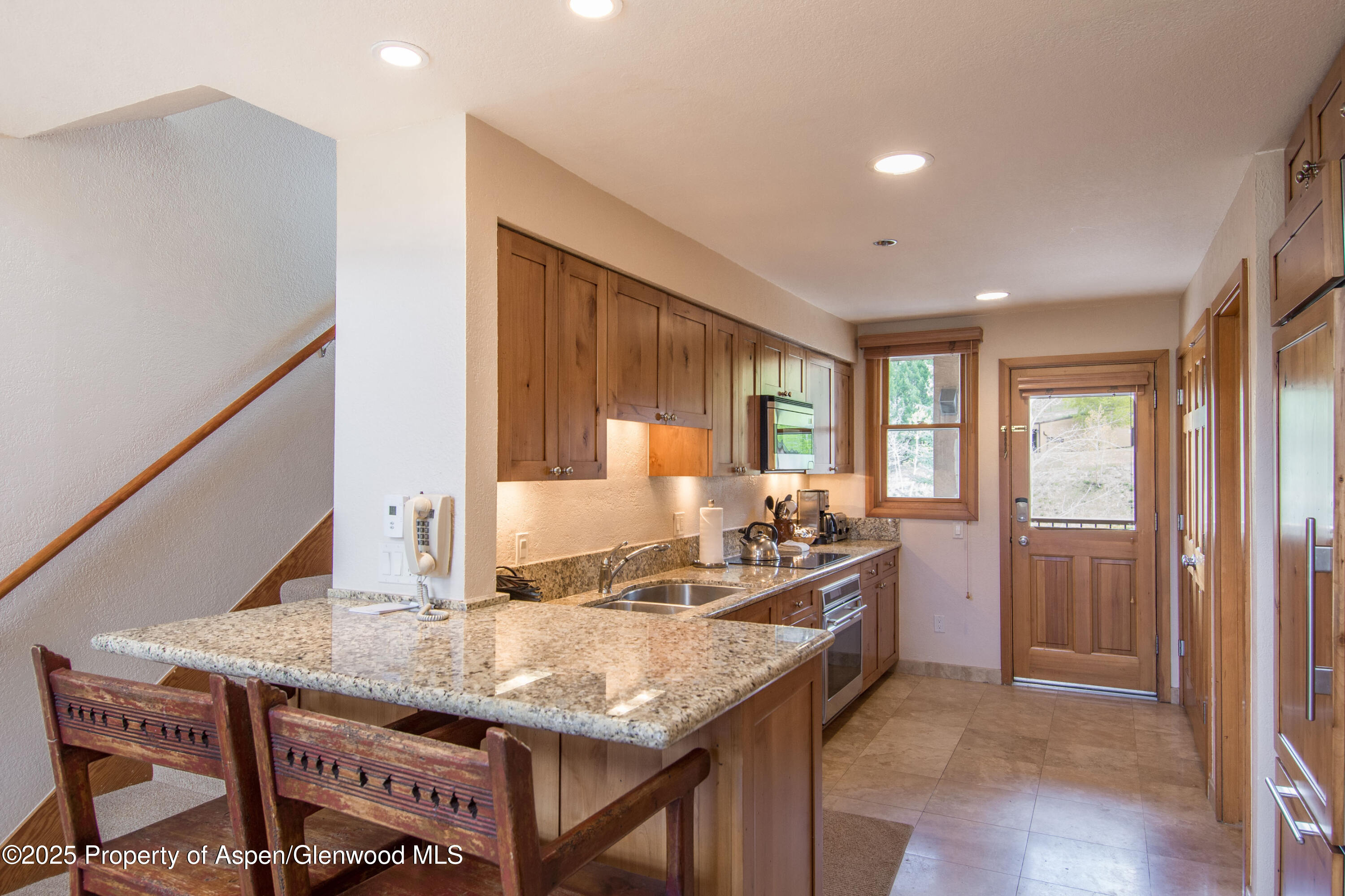 425 Wood Road, Unit 48 Snowmass Village, CO 81615 - Photo 16 of 39 a kitchen with granite countertop a stove a sink and a refrigerator