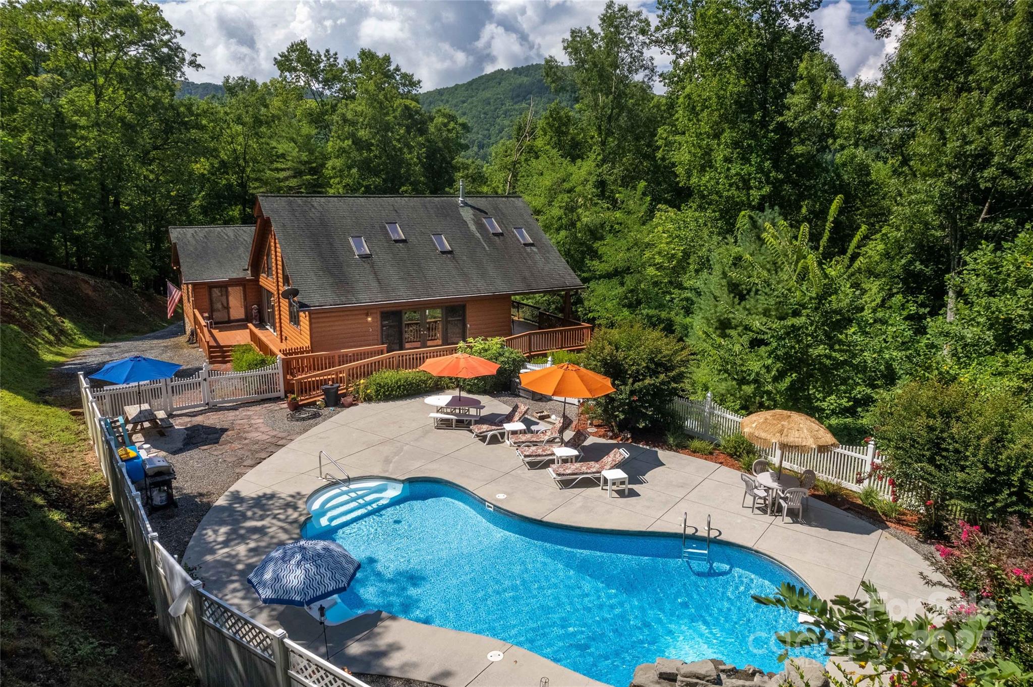 an aerial view of a house with swimming pool and patio