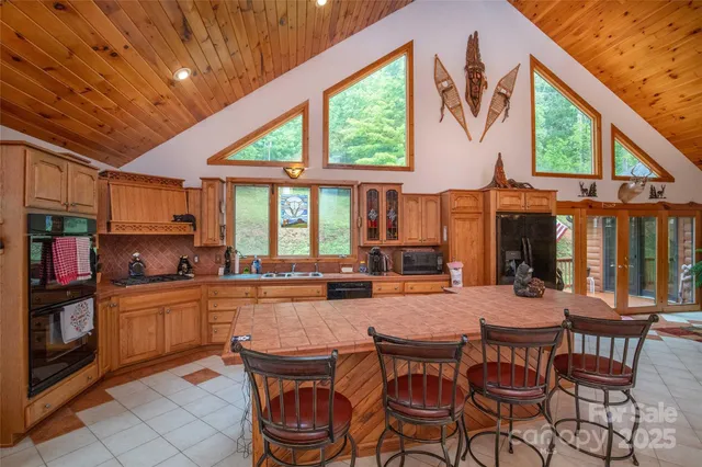 a dining room with stainless steel appliances granite countertop a stove a kitchen island a table and chairs