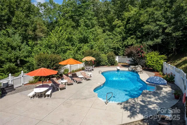 a view of backyard with swimming pool and seating space