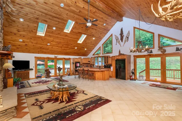 a living room with furniture a large window and flat screen tv