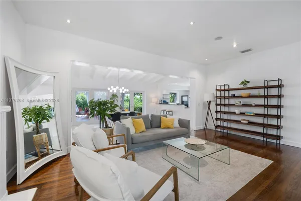 a living room with furniture and potted plants