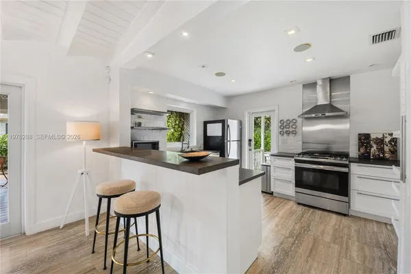 a kitchen with stainless steel appliances a stove a sink a microwave a refrigerator and cabinets
