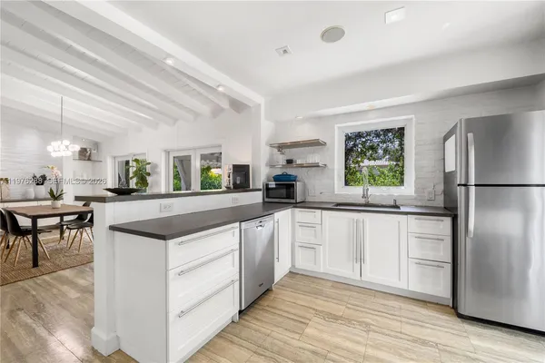 a kitchen with white cabinets and a refrigerator