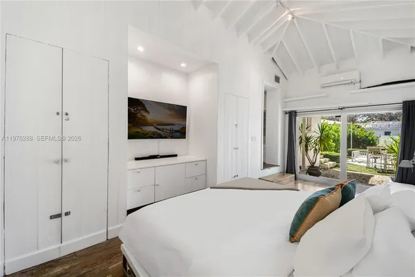 a bedroom with a bed and a flat screen tv