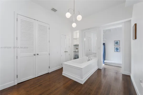 a view of a bedroom with wooden floor