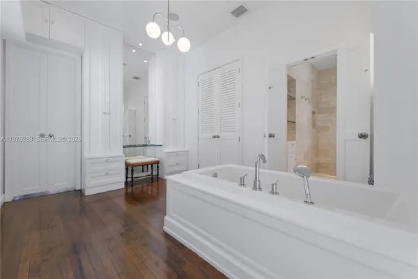 a bathroom with a bathtub a sink and a chandelier