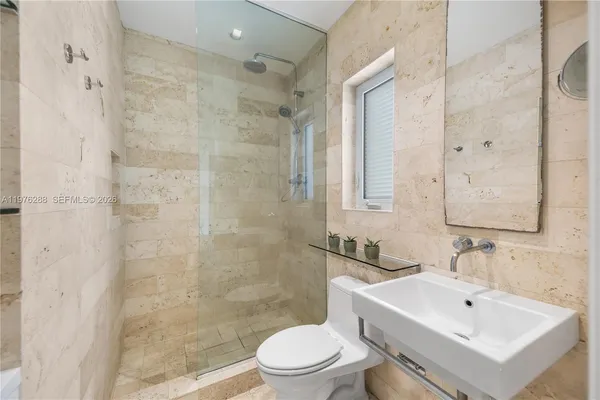 a bathroom with a sink mirror toilet and shower