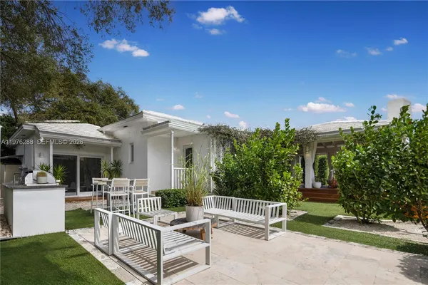 a view of a patio with couches table and chairs and potted plants