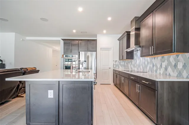 a kitchen with stainless steel appliances granite countertop a sink a stove and a refrigerator