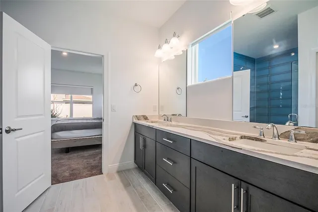 a bathroom with a sink a toilet and a large mirror