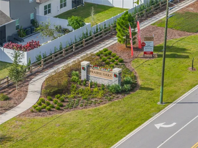 an aerial view of a residential houses with outdoor space and trees