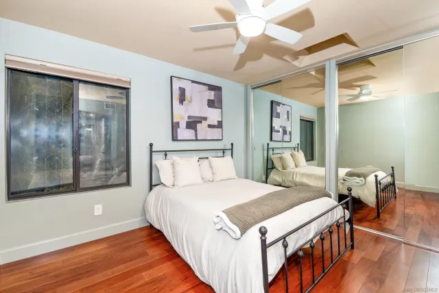 a bedroom with a bed and a large mirror with a flat screen tv