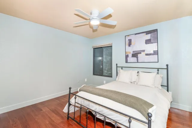 a bedroom with a bed and a painting on the wall