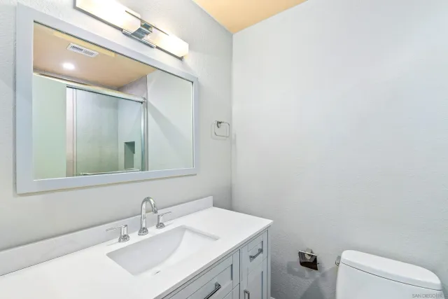 a bathroom with a sink mirror vanity and toilet