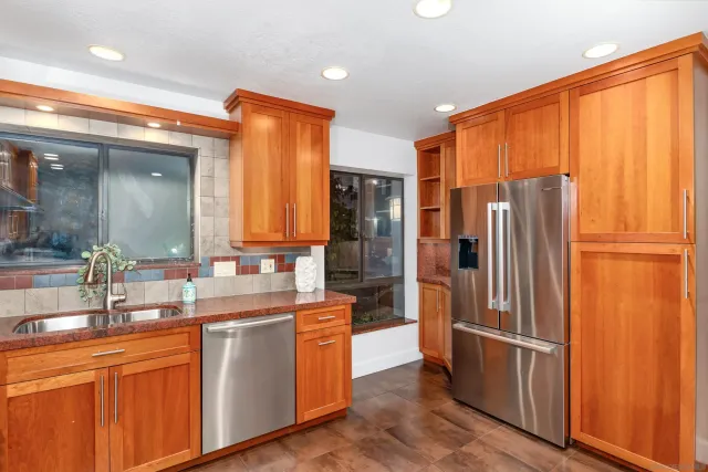 a kitchen with stainless steel appliances granite countertop a refrigerator and a sink