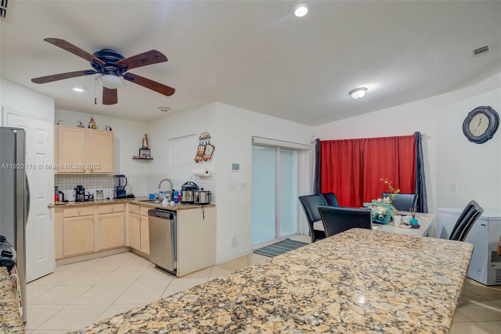 530 7th Street Southwest Naples, FL 34117 - Photo 12 of 32 a kitchen with stainless steel appliances granite countertop a stove top oven a refrigerator a sink dishwasher with a dining table and chairs