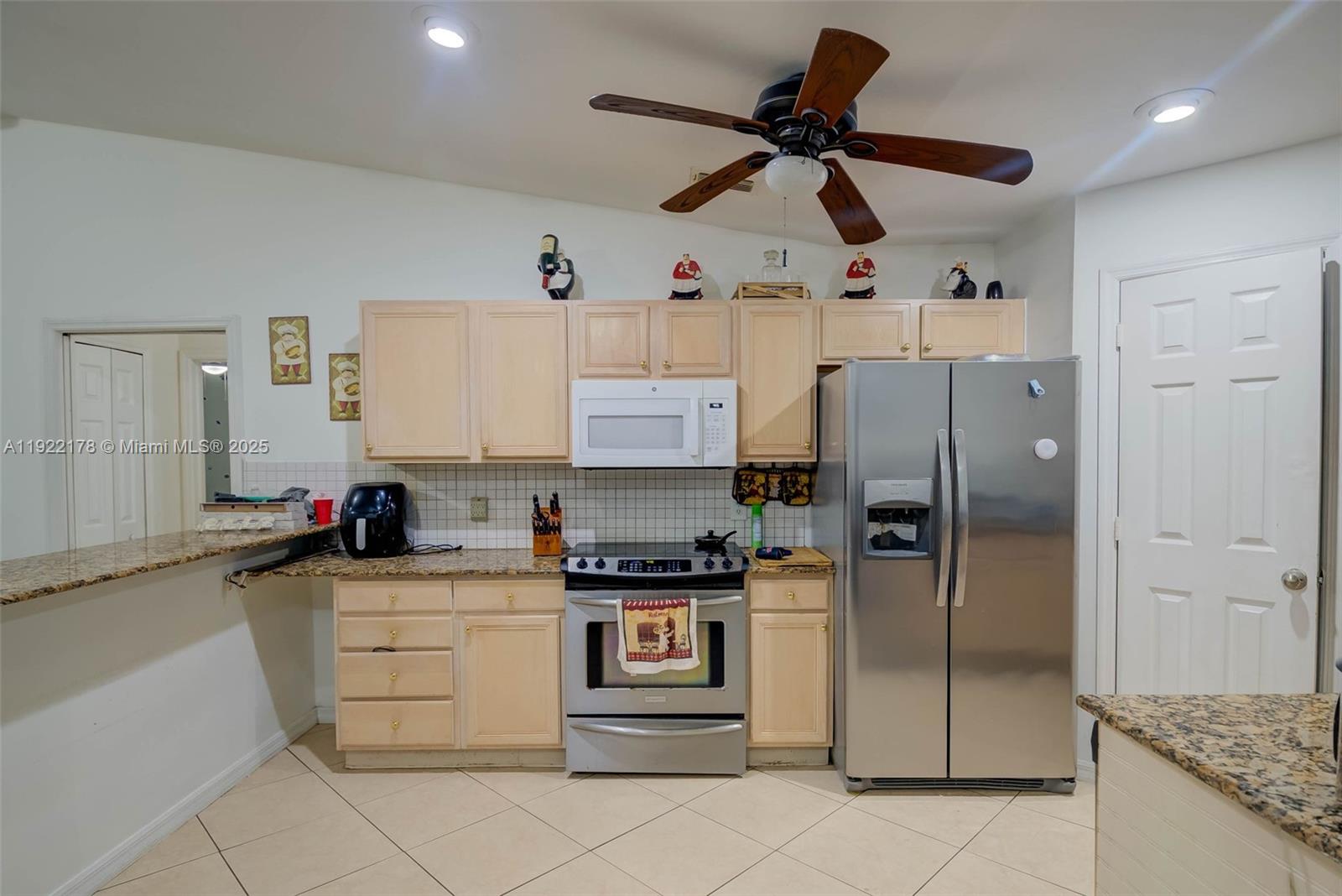 530 7th Street Southwest Naples, FL 34117 - Photo 13 of 32 a kitchen with stainless steel appliances kitchen island granite countertop a refrigerator and a sink