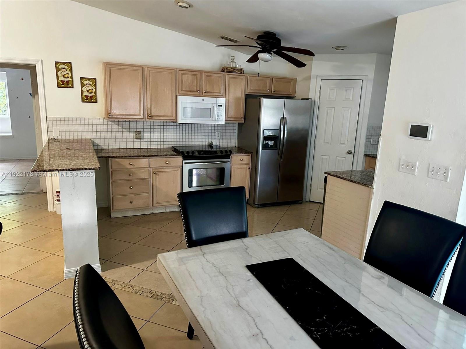 530 7th Street Southwest Naples, FL 34117 - Photo 14 of 32 a kitchen with stainless steel appliances a refrigerator a sink a stove and white cabinets