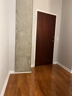 an empty room with wooden floor and entrance