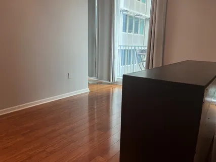 a view of a big room with wooden floor and windows