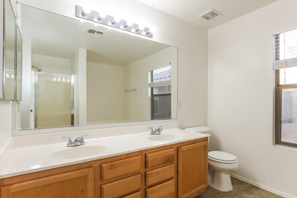 9415 Virginia Avenue Phoenix, AZ 85037 - Photo 15 of 17 a bathroom with a double vanity sink and a mirror