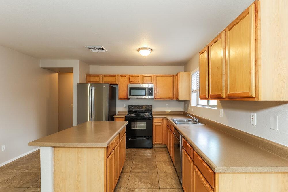 9415 Virginia Avenue Phoenix, AZ 85037 - Photo 7 of 17 a kitchen with stainless steel appliances granite countertop a sink stove and refrigerator
