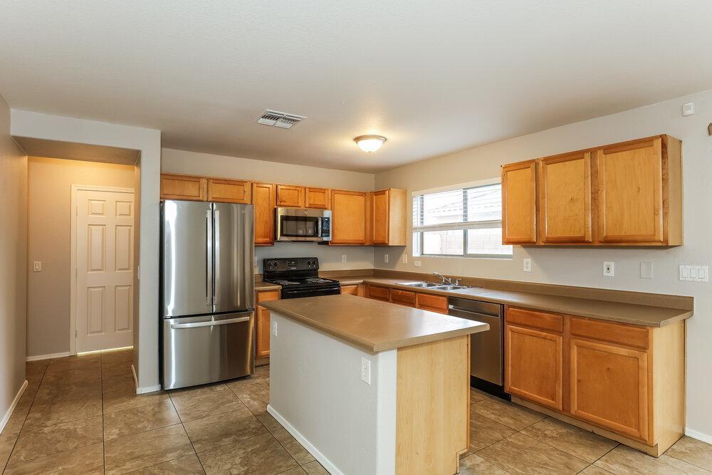 9415 Virginia Avenue Phoenix, AZ 85037 - Photo 8 of 17 a kitchen with stainless steel appliances granite countertop a refrigerator and a sink